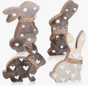 Four wooden bunny figurines with a a heart pattern